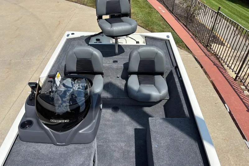 Slide: The Image of 2026 Tracker Pro 170 boat interior with gray seating and console, parked on concrete. - 4