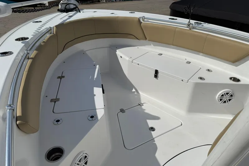 Slide: The Image of 2018 Sportsman Open 232 Center Console boat interior with cushioned seating and storage compartments. - 6