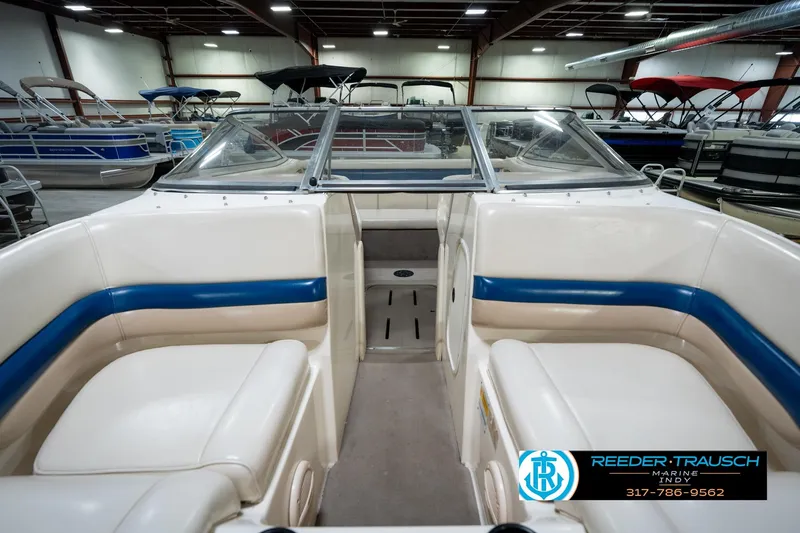 Slide: The Image of 2000 Bryant 196 Limited boat interior with beige and blue seating in showroom. - 14