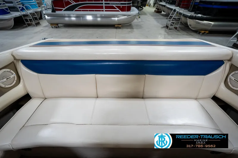 Slide: The Image of White and blue seating on a 2000 Bryant 196 Limited boat in showroom. - 16