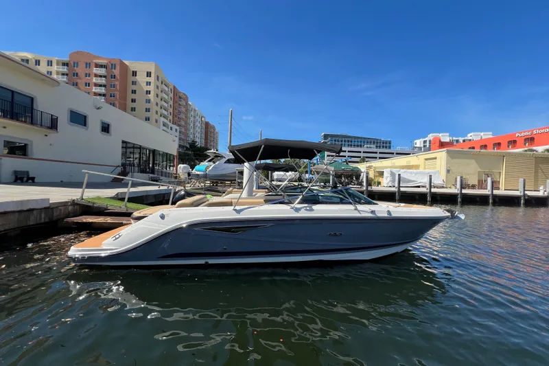 The Image of 2020 Sea Ray 280 SLX boat docked in urban marina under clear blue sky. - 0