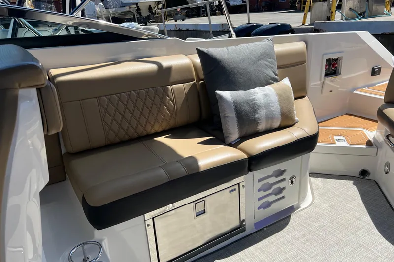 Slide: The Image of 2020 Sea Ray 280 SLX boat interior with tan seating and decorative pillows. - 12