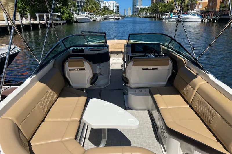 Slide: The Image of 2020 Sea Ray 280 SLX boat interior with tan seating, table, and waterfront view. - 17