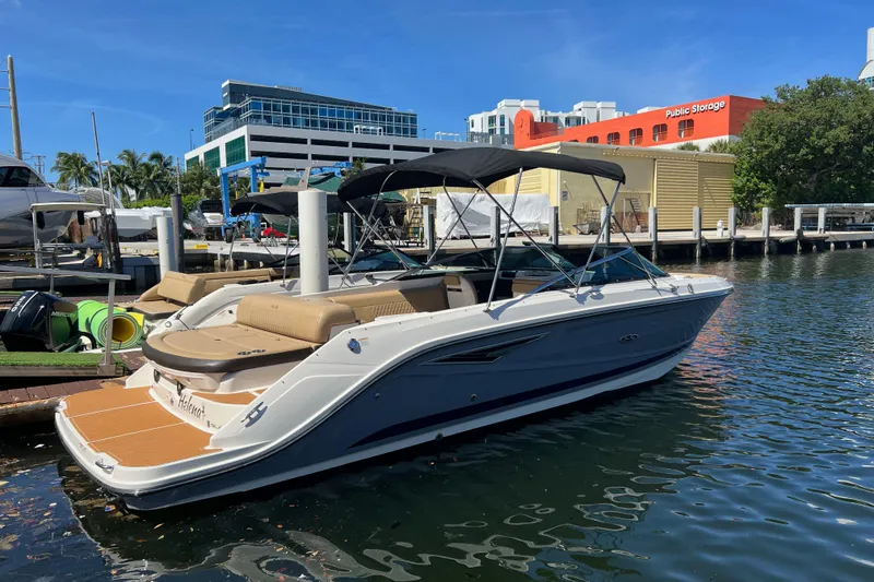 Slide: The Image of 2020 Sea Ray 280 SLX boat docked at marina with modern buildings in background. - 3
