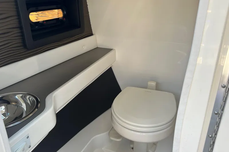 Slide: The Image of 2020 Sea Ray 280 SLX boat interior with compact bathroom and window. - 30