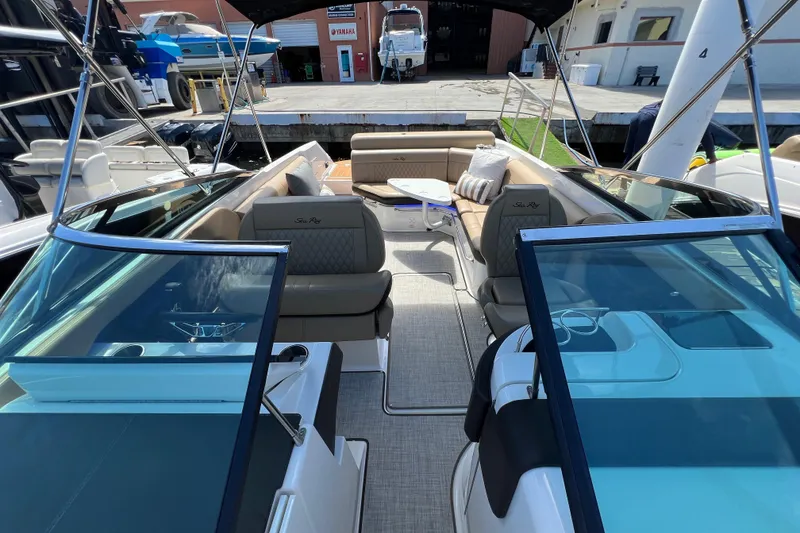 Slide: The Image of 2020 Sea Ray 280 SLX boat interior with seating and table, docked at marina. - 37