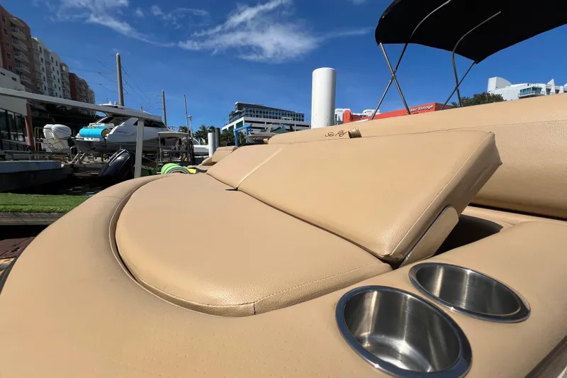 Slide: The Image of 2020 Sea Ray 280 SLX boat with tan leather seating and cup holders, docked under blue sky. - 5