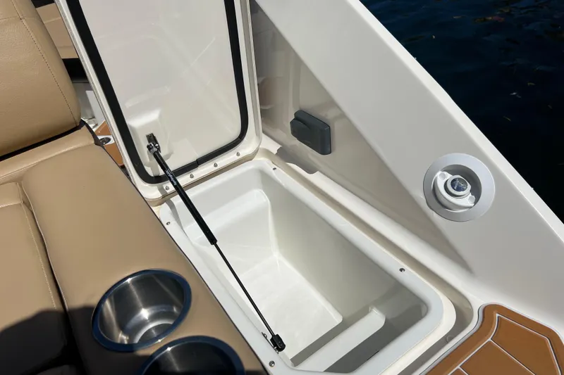 Slide: The Image of 2020 Sea Ray 280 SLX boat interior with open storage compartment and cup holders. - 51