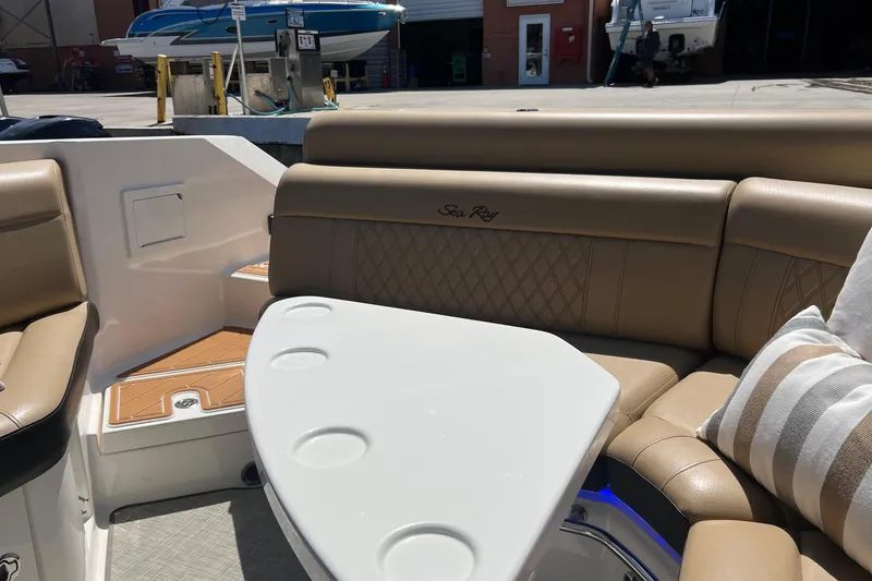Slide: The Image of 2020 Sea Ray 280 SLX boat interior with tan leather seating and white table. - 8