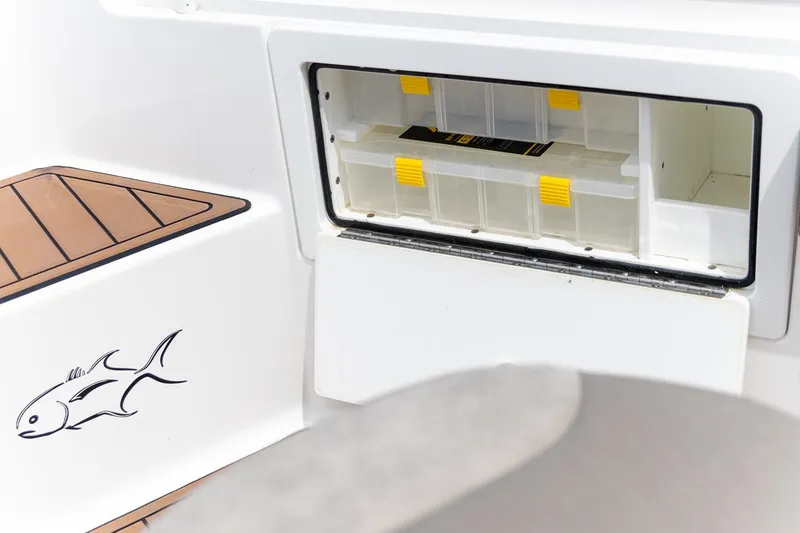 Slide: The Image of 2022 Crevalle 26 HBW boat storage compartment with fish decal and tackle box. - 13