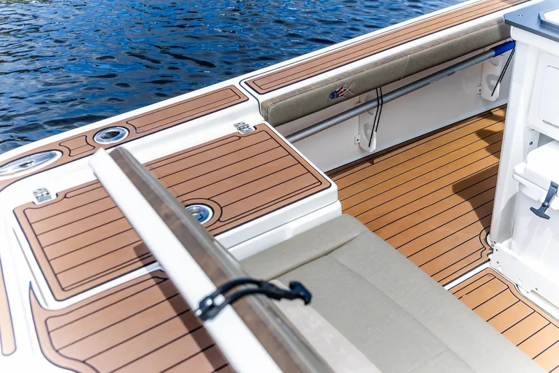 Slide: The Image of 2022 Crevalle 26 HBW boat interior with teak flooring and cushioned seating. - 23