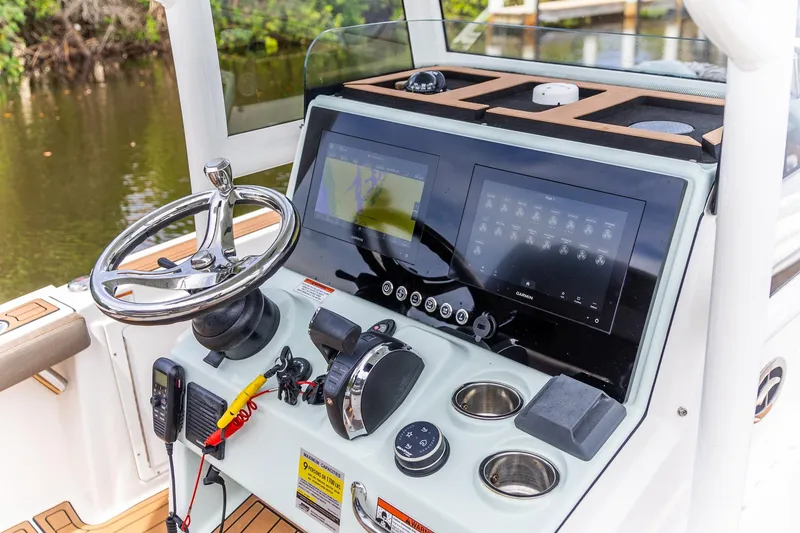 Slide: The Image of 2022 Crevalle 26 HBW boat dashboard with steering wheel and digital displays. - 3