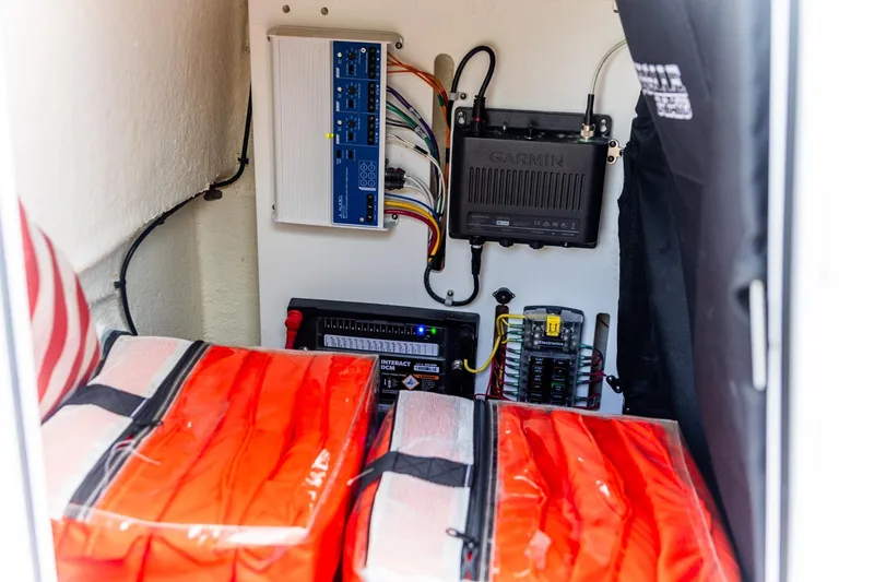 Slide: The Image of Electrical components and safety gear inside a 2022 Crevalle 26 HBW boat compartment. - 30