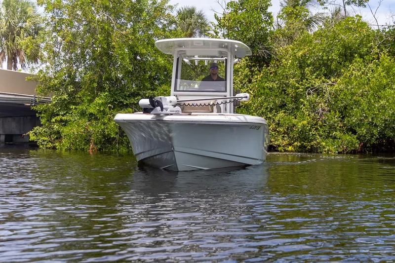 Slide: The Image of 2022 Crevalle 26 HBW boat navigating through lush, green waterside vegetation. - 37