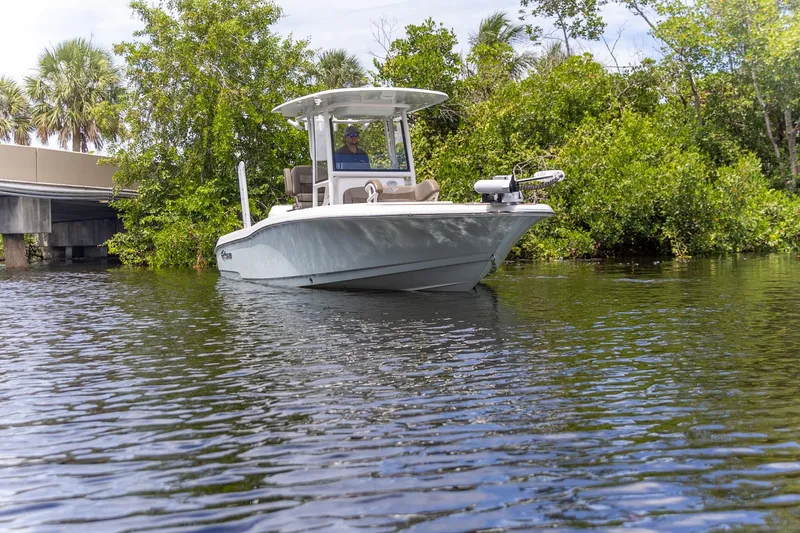 Slide: The Image of 2022 Crevalle 26 HBW boat cruising on a calm river near lush greenery. - 39