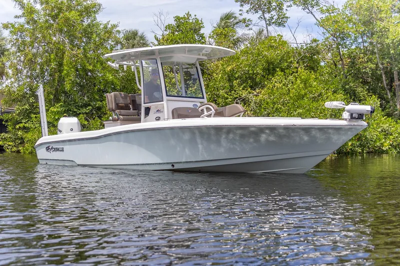 Slide: The Image of 2022 Crevalle 26 HBW boat on calm water, surrounded by lush greenery. - 41