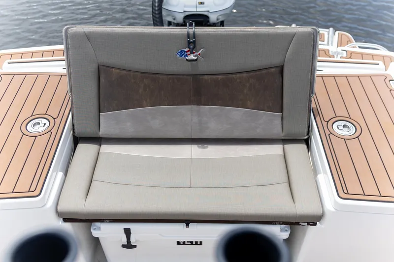 Slide: The Image of 2022 Crevalle 26 HBW boat seat with cushioned backrest and teak deck accents. - 5