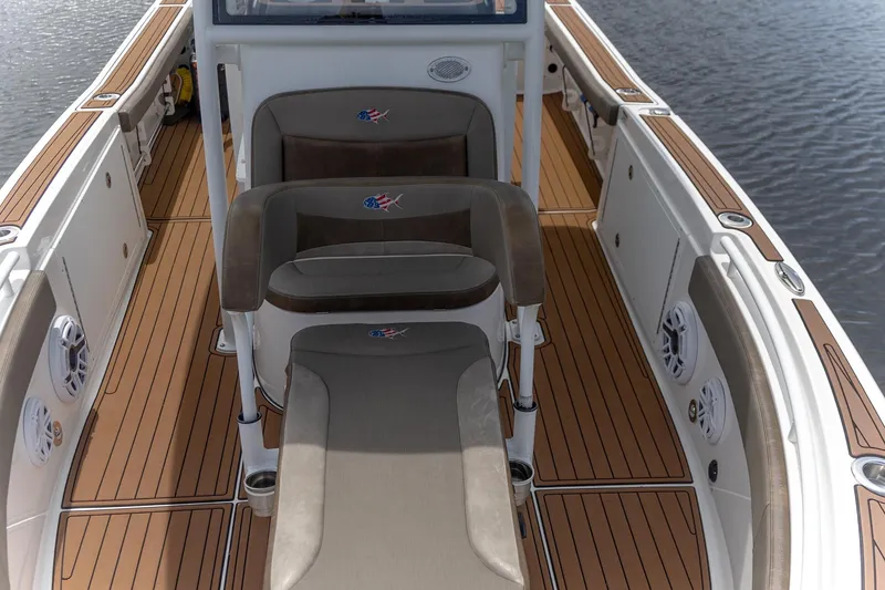 Slide: The Image of 2022 Crevalle 26 HBW boat interior with teak flooring and cushioned seating. - 7