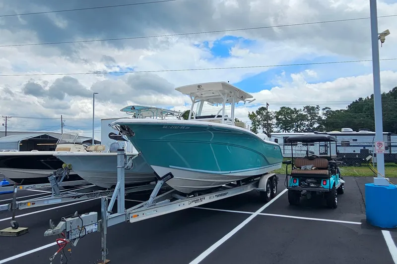 Slide: The Image of 2018 Sea Fox 266 Commander boat on trailer in parking lot under cloudy sky. - 1