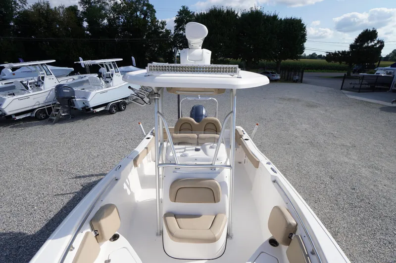 Slide: The Image of 2019 Tidewater 220 LXF boat with beige seating, parked on gravel lot with other boats. - 11