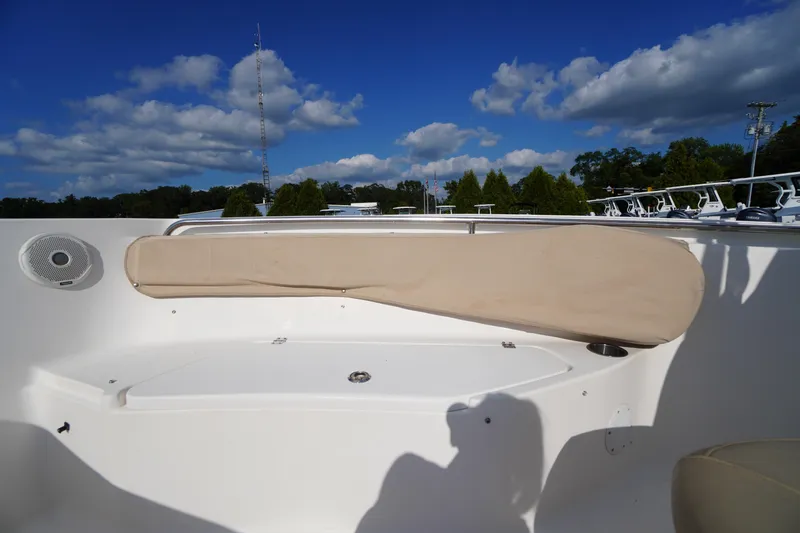 Slide: The Image of 2019 Tidewater 220 LXF boat interior with cushioned seating and speaker under a blue sky. - 14