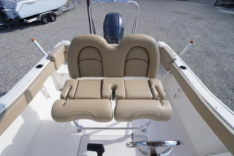 Slide: The Image of 2019 Tidewater 220 LXF boat with beige seating and steering wheel, parked on gravel. - 36