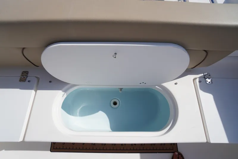 Slide: The Image of 2019 Tidewater 220 LXF boat livewell with beige seating and white cover. - 43