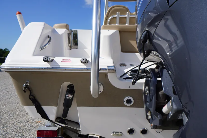 Slide: The Image of 2019 Tidewater 220 LXF boat stern with motor and trim tabs, parked on gravel. - 48