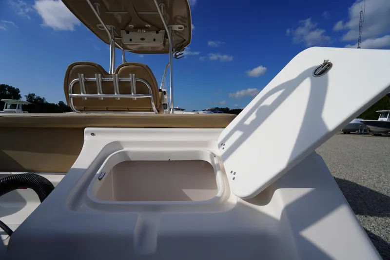 Slide: The Image of 2019 Tidewater 220 LXF boat with open storage compartment under clear blue sky. - 51