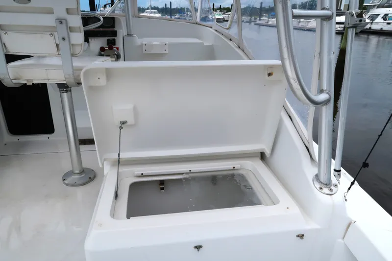 Slide: The Image of 1997 Luhrs Tournament 290 boat interior with open storage compartment and seating. - 12
