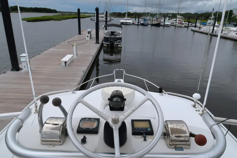 Slide: The Image of 1997 Luhrs Tournament 290 boat helm at marina dock, steering wheel and controls visible. - 15