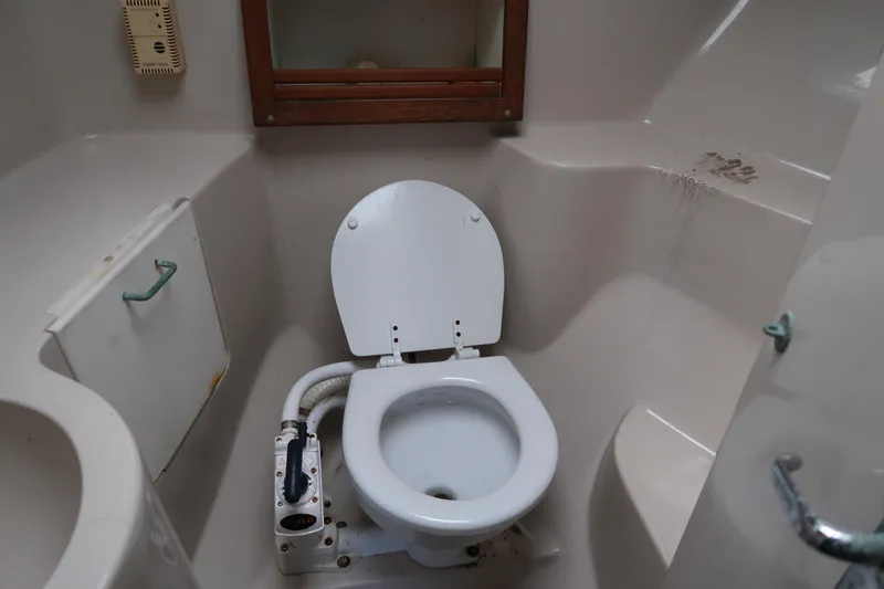 Slide: The Image of Bathroom interior of 1997 Luhrs Tournament 290 boat, featuring a marine toilet. - 16