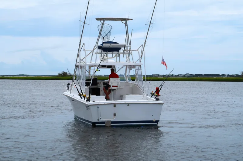 Slide: The Image of 1997 Luhrs Tournament 290 boat on calm water, equipped for fishing, with American flag. - 2