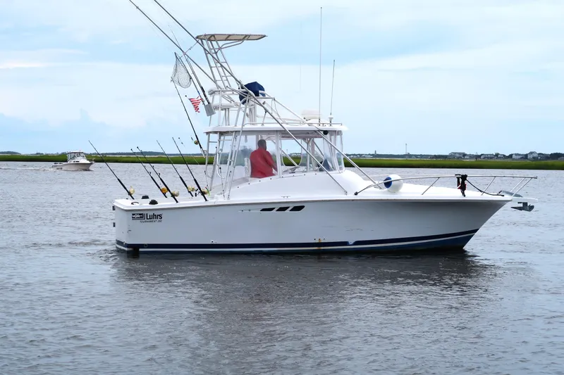 Slide: The Image of 1997 Luhrs Tournament 290 boat on calm water, equipped for fishing. - 3