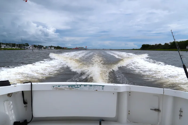Slide: The Image of 1997 Luhrs Tournament 290 boat cruising, leaving a wake on a cloudy day. - 6