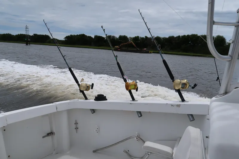 Slide: The Image of 1997 Luhrs Tournament 290 boat with fishing rods on a river. - 8