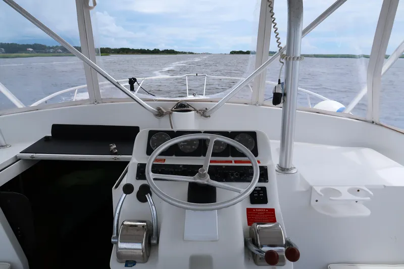 Slide: The Image of 1997 Luhrs Tournament 290 boat helm with steering wheel and controls on open water. - 9