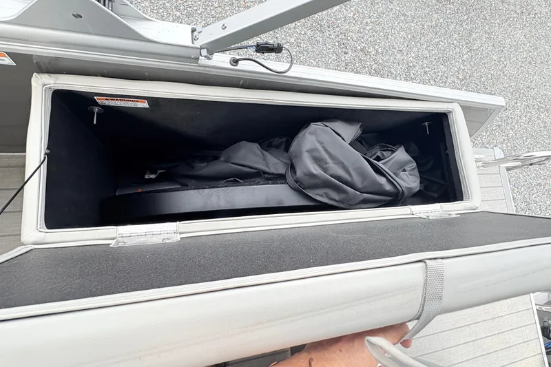 Slide: The Image of 2024 Starcraft 20 EX QDH boat interior with white and gray seating, RVs and boats in background. - 13