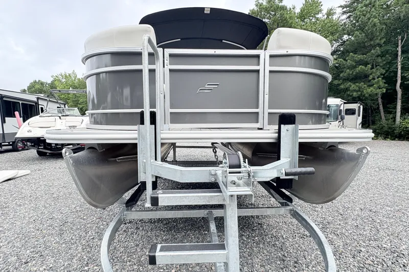 Slide: The Image of 2024 Starcraft 20 EX QDH pontoon boat with canopy, docked outdoors. - 3