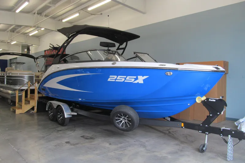 Slide: The Image of 2025 Yamaha Boats 255XD in showroom, blue hull, on trailer. - 1