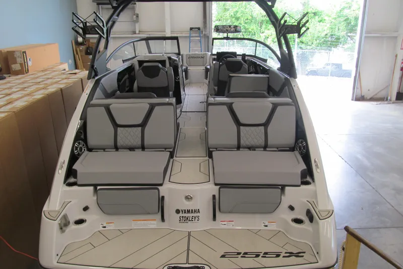 Slide: The Image of 2025 Yamaha Boats 255XD interior with sleek seating and modern design in a showroom. - 3