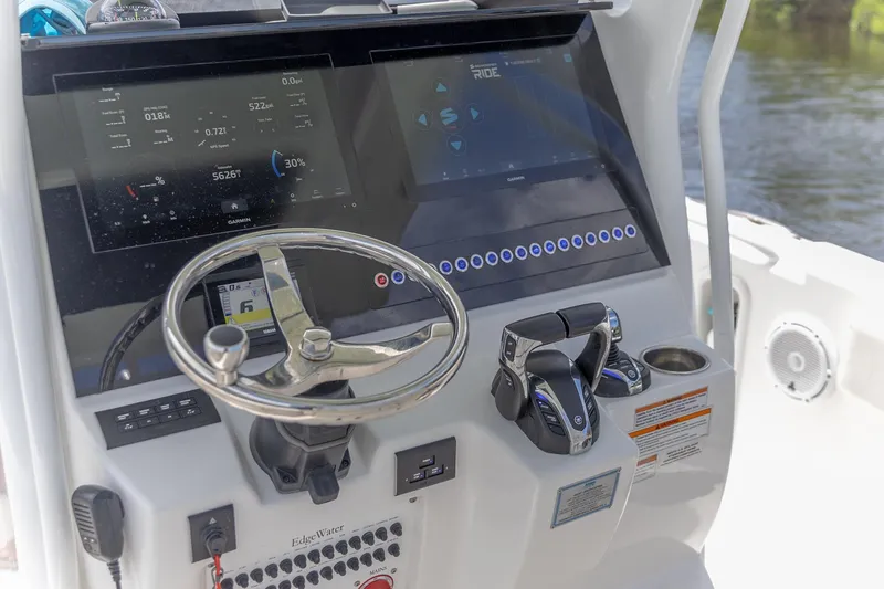 Slide: The Image of 2023 Edgewater 262CC boat dashboard with steering wheel and digital controls. - 1