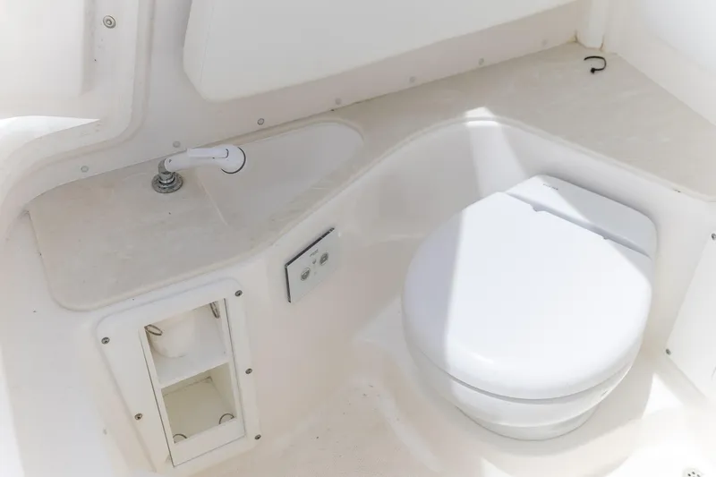 Slide: The Image of 2023 Edgewater 262CC boat interior with compact marine toilet and sink. - 10