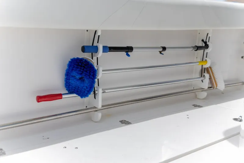 Slide: The Image of Storage compartment on 2023 Edgewater 262CC boat with cleaning tools and brushes. - 15