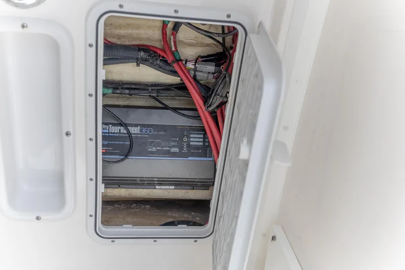 Slide: The Image of 2023 Edgewater 262CC boat compartment with ProTournament 360 battery charger and wiring. - 17