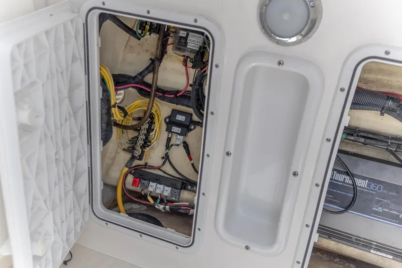 Slide: The Image of 2023 Edgewater 262CC boat electrical compartment with wiring and components. - 18