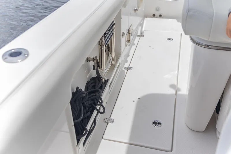Slide: The Image of 2023 Edgewater 262CC boat interior with storage compartment and coiled rope. - 19