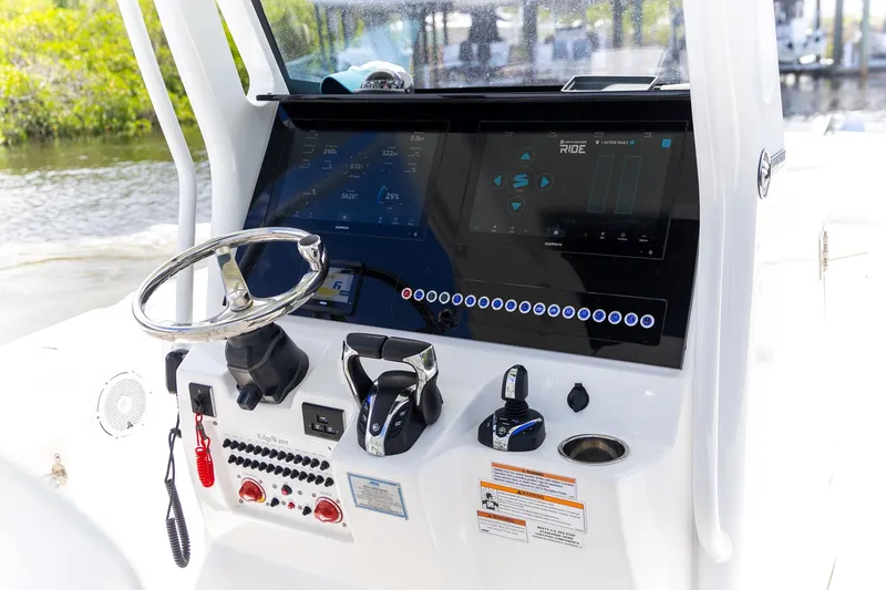 Slide: The Image of 2023 Edgewater 262CC boat dashboard with steering wheel and digital controls. - 23