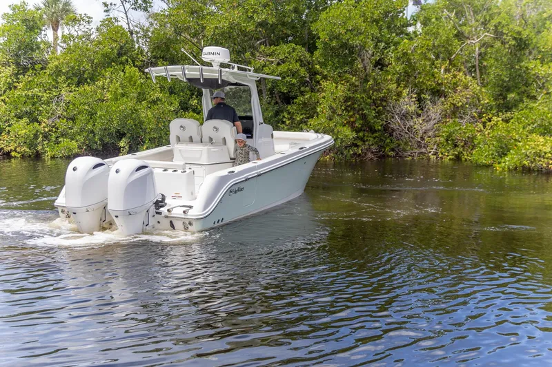 Slide: The Image of 2023 Edgewater 262CC boat cruising on a calm river surrounded by lush greenery. - 27