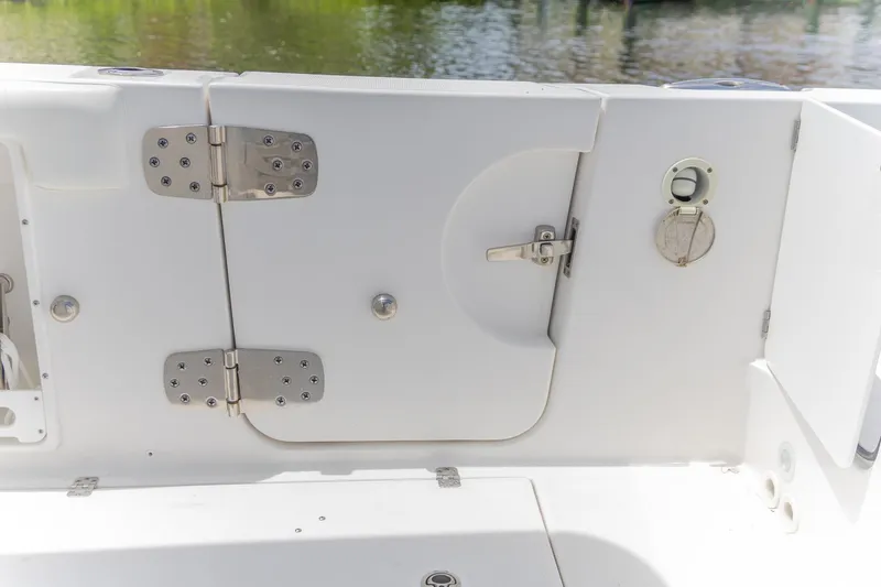 Slide: The Image of 2023 Edgewater 262CC boat interior, featuring a white hatch door with metal hinges and latch. - 3